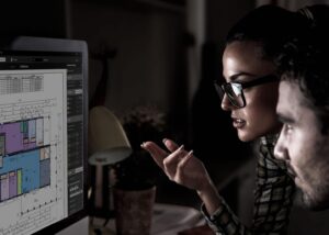 two stdents looking at a computer doing the SAFE RITE owner builder course
